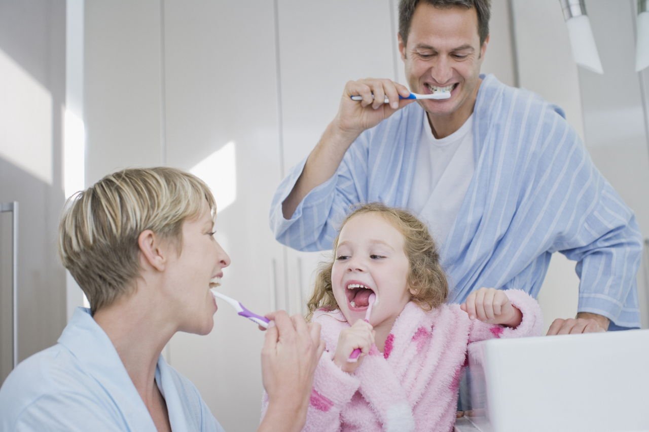 Дети чистят зубы с родителями